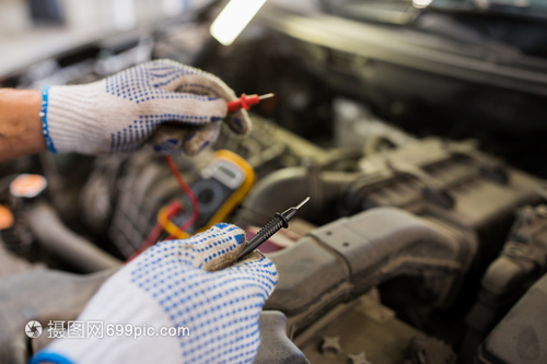 汽车服务,维修,维护人的汽车技工与数字万用表测试电池车间汽车机械师与万用表测试电池